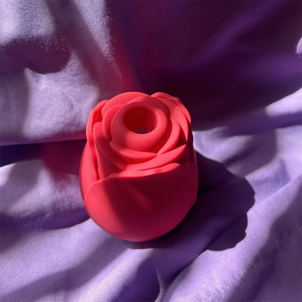 Roselle Aura Wide-Opening Rose Suction Toy — red wide-opening rose toy on purple fabric